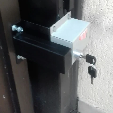 Trava elétrica instalada em portão social de alumínio, vista da fixação lateral
